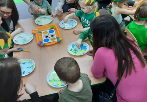 Dzieci wspólnie z rodzicami wykonują eksperyment "kolorowe mleko"
